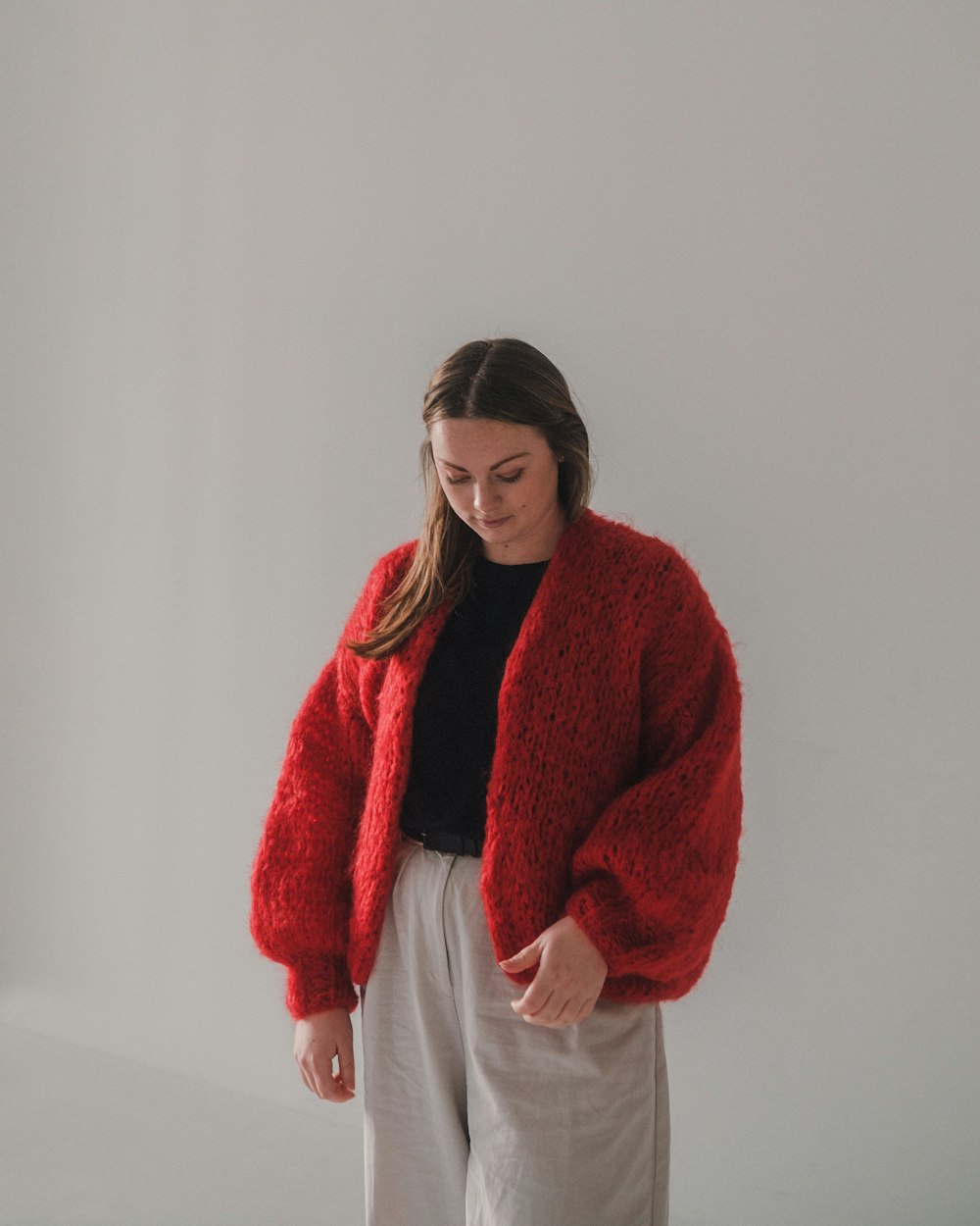 woman in red sweater and white pants