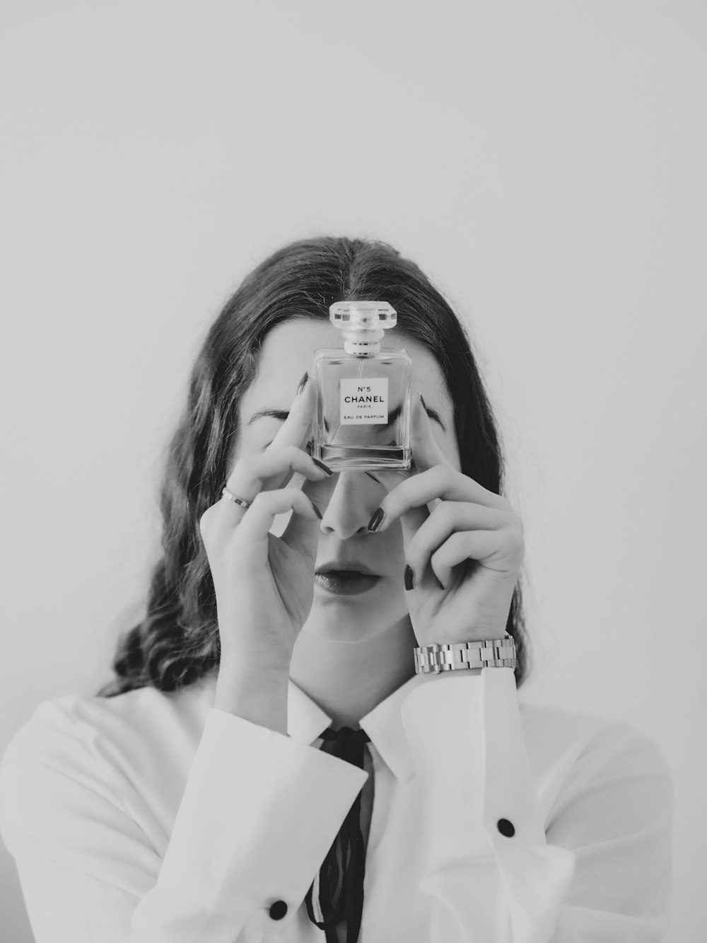 woman in white long sleeve shirt holding iphone