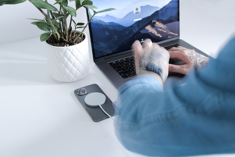 person in blue shirt using macbook pro