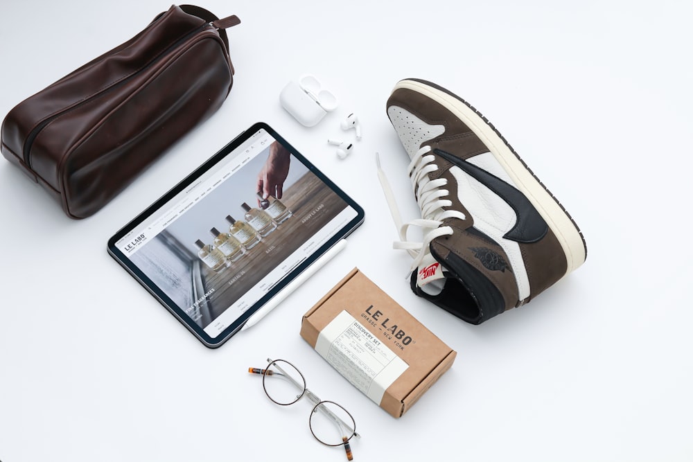 black framed eyeglasses beside brown leather bag