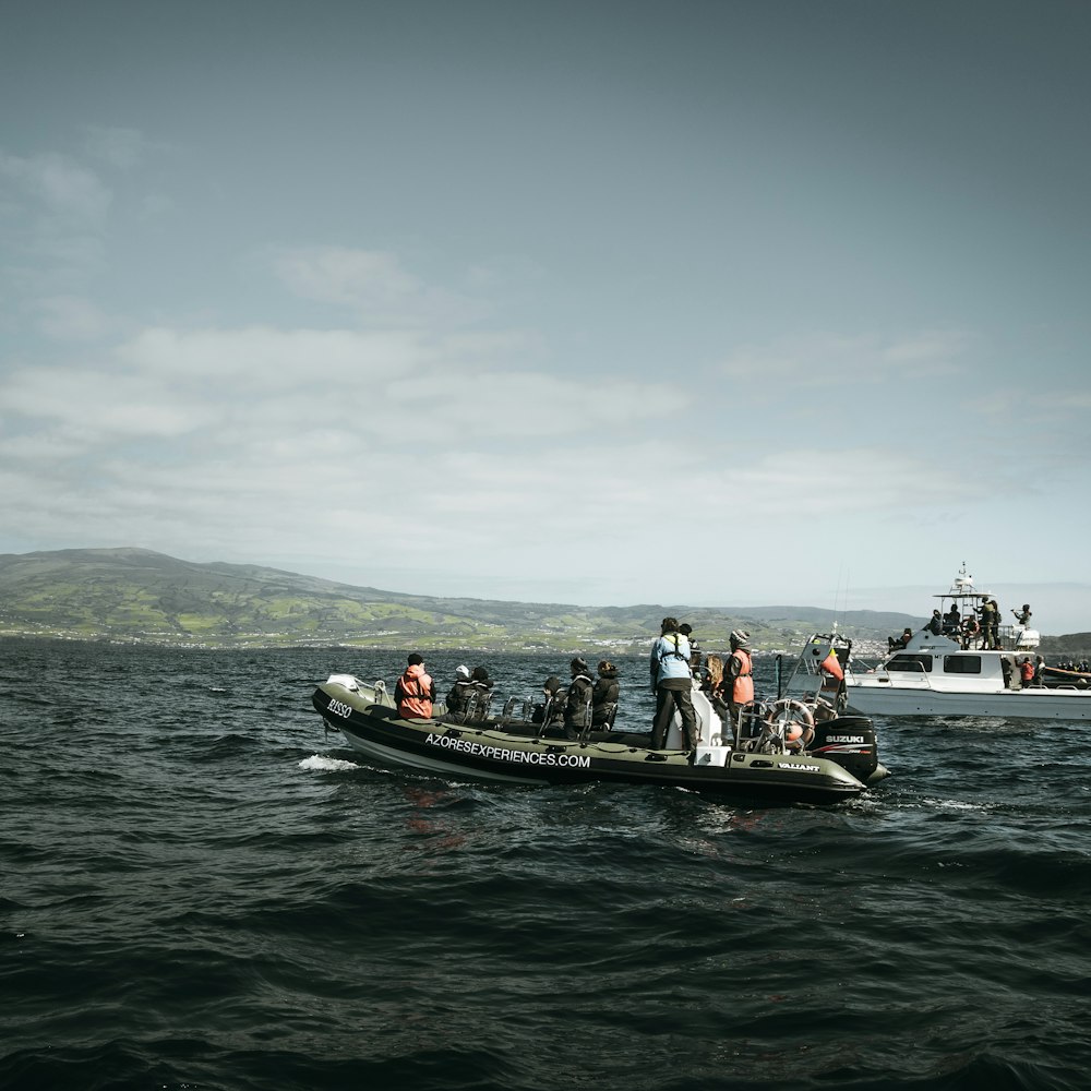 personas que viajan en un bote negro y rojo en el mar durante el día