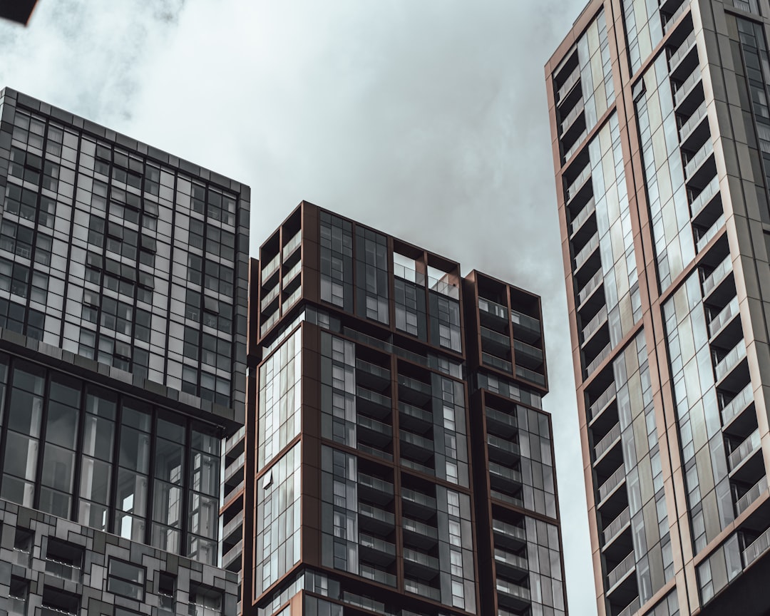 brown and black concrete building under white clouds