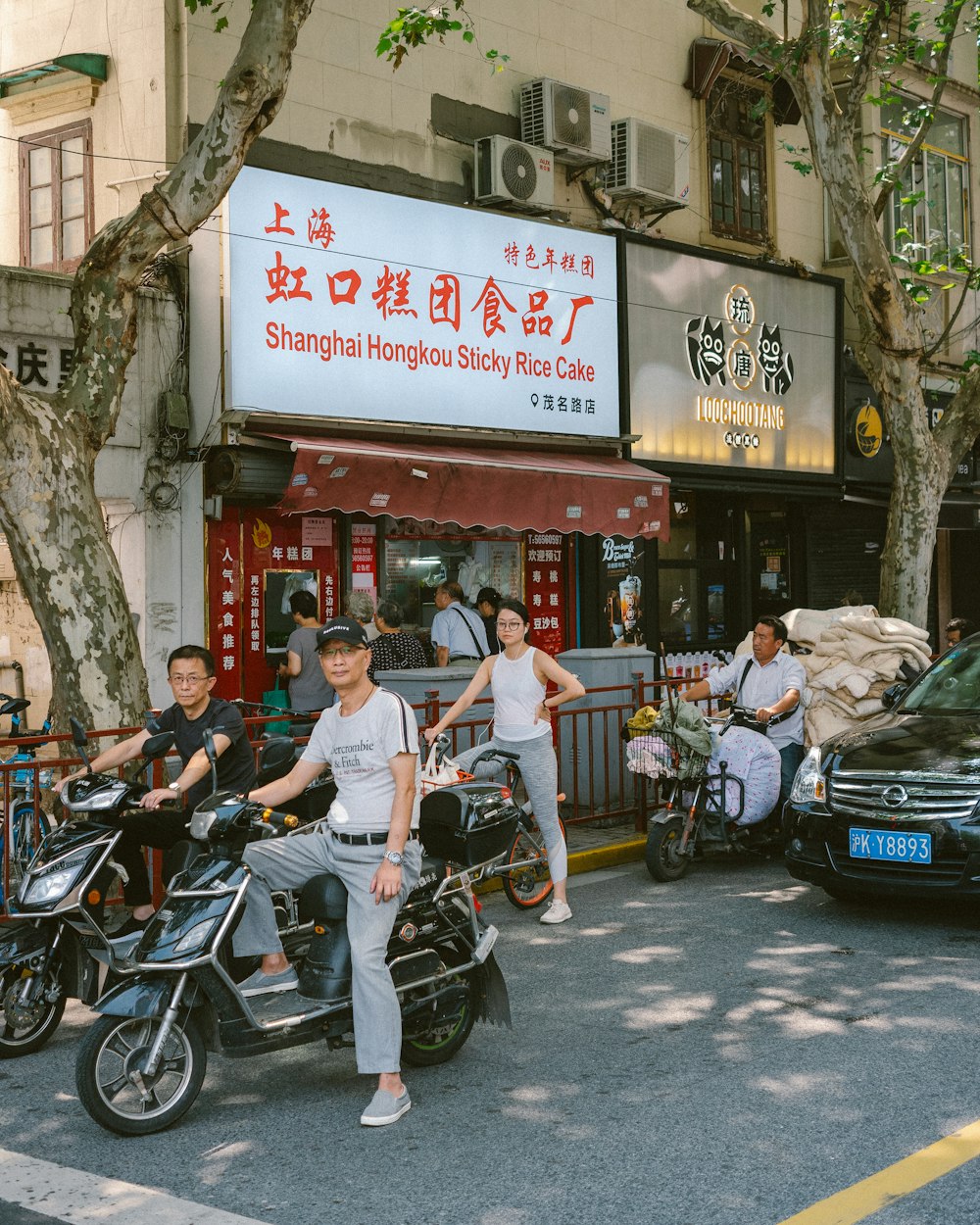 man in white t-shirt and blue denim jeans sitting on black motorcycle during daytime