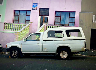 A blue pickup truck parked outside the Taller Nueva Era with a fresh coat of paint.
