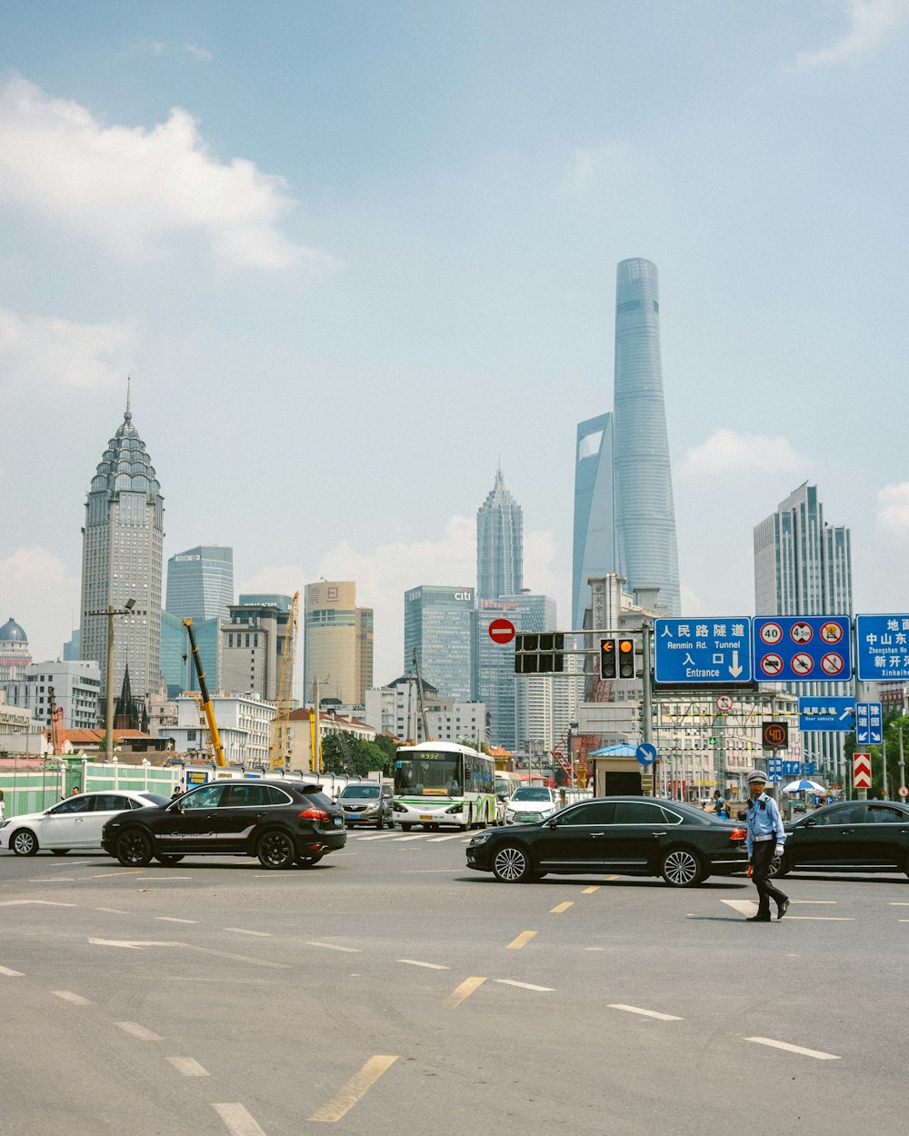 cars parked on side of the road near high rise buildings during daytime