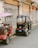 Two small vehicles are parked beside a wall with Chinese writing. The first vehicle is a red scooter-like vehicle with a purple canopy, while the second is a small black electric tricycle with its doors open. The wall in the background is aged and shows visible electrical wires.