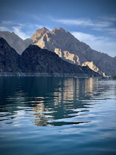 blue body of water near mountain during daytime