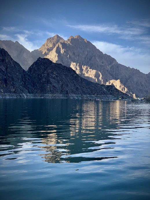 blue body of water near mountain during daytime