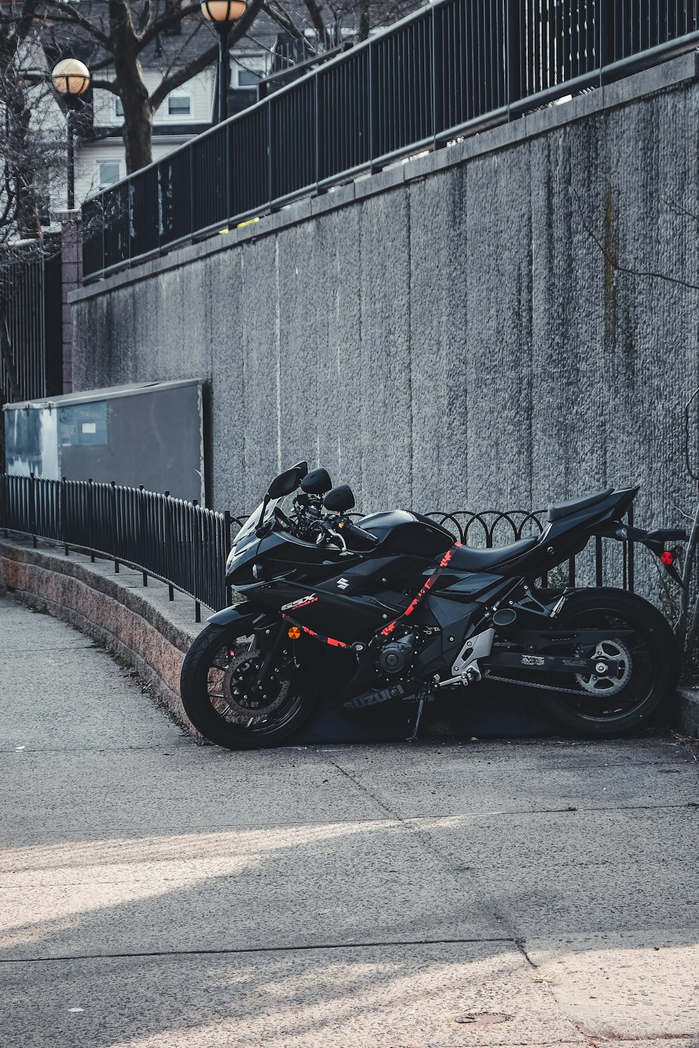 black sports bike parked beside wall