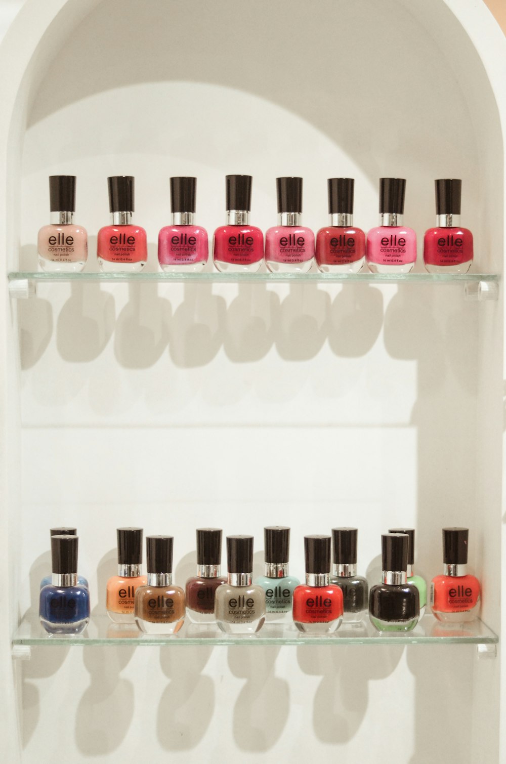 assorted nail polish bottles on white shelf