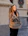 A smiling woman wearing a cozy, stylish hoodie from vėjas, standing in a sunlit urban street.