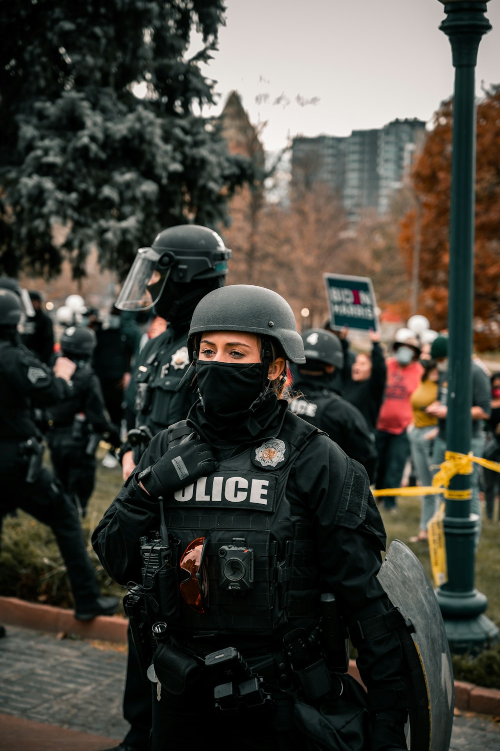 man in black helmet and black jacket standing near people during daytime