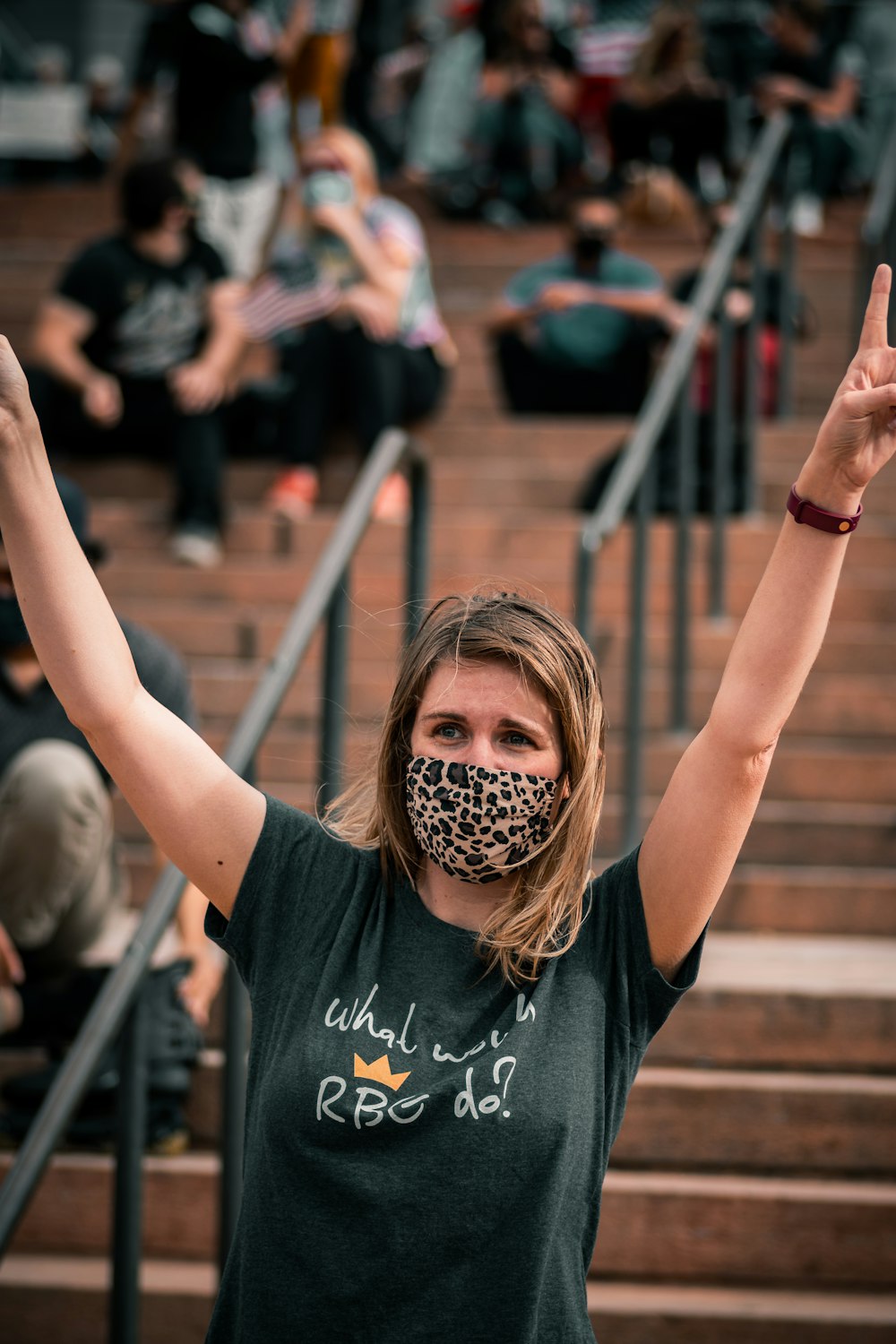 woman in black crew neck t-shirt raising her hands