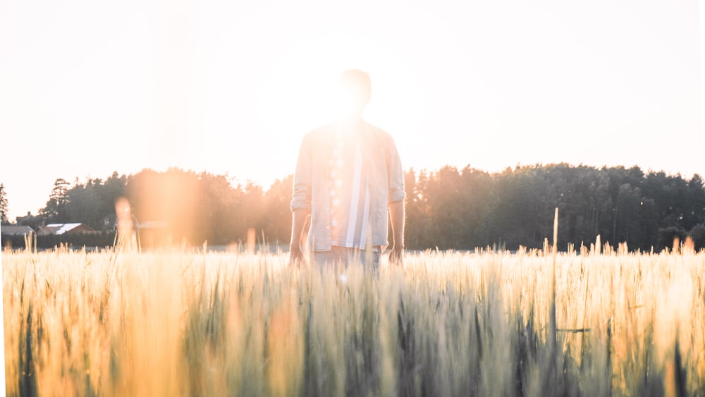 man in white dress shirt standing on green grass field during daytime