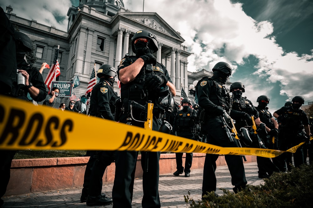 group of men in black and yellow jacket holding yellow banner