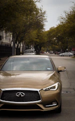 A shiny preowned sedan parked on a sunny suburban street.