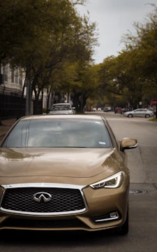 A shiny preowned sedan parked on a sunny suburban street.