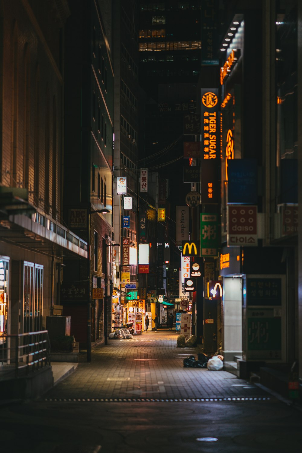 people walking on sidewalk during night time