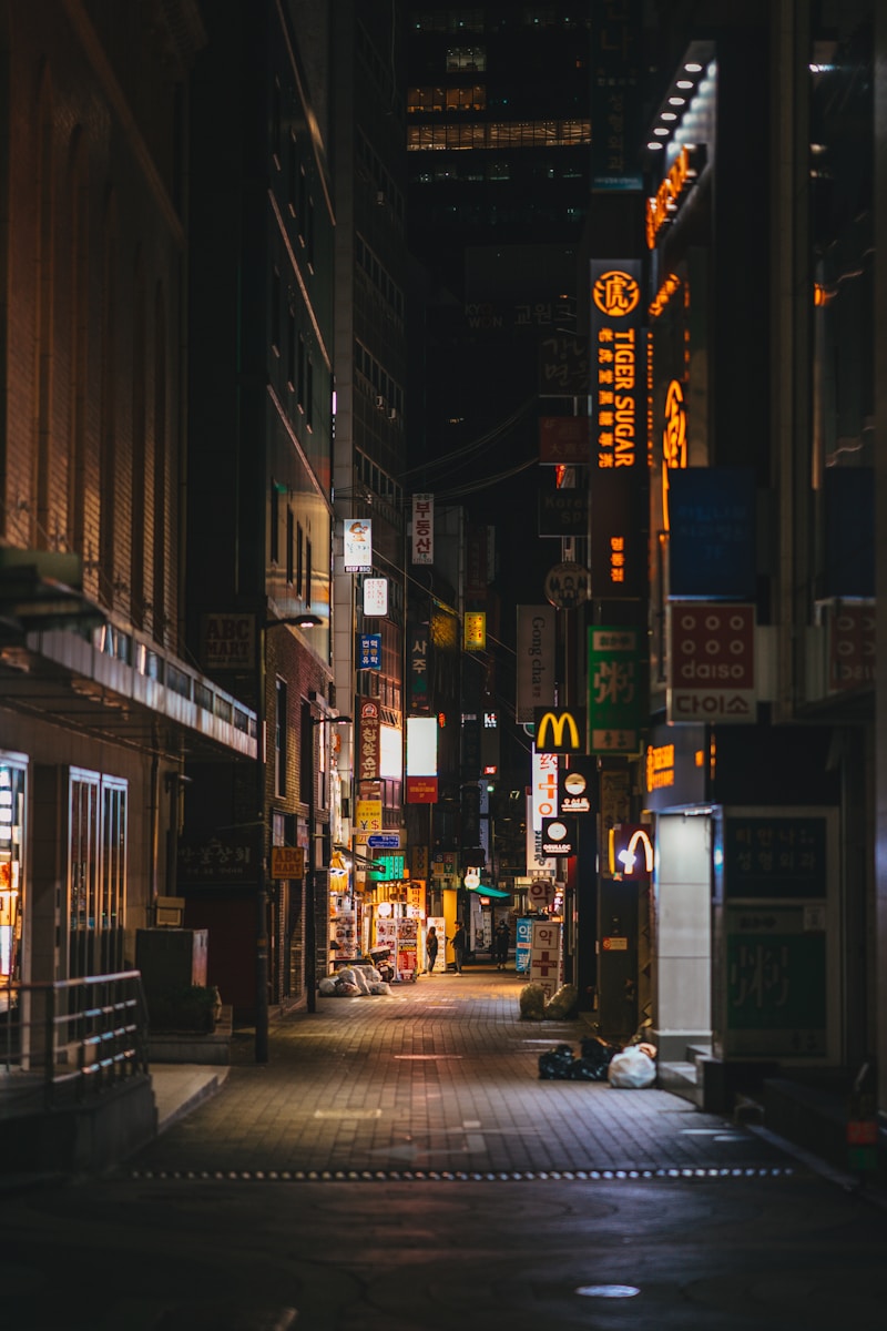 People walking a Seoul sidewalk at night