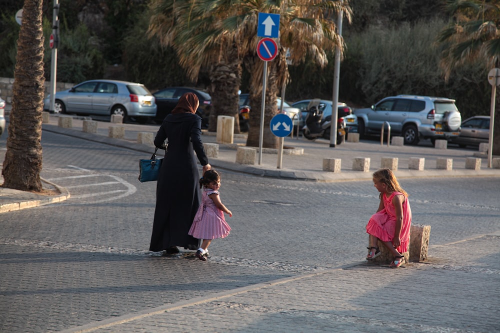 woman in black hijab walking on sidewalk during daytime