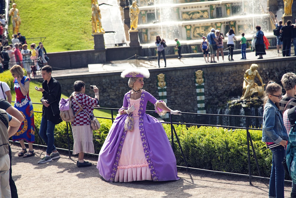 Muchacha en vestido rosa de pie en el suelo de hormigón gris durante el día