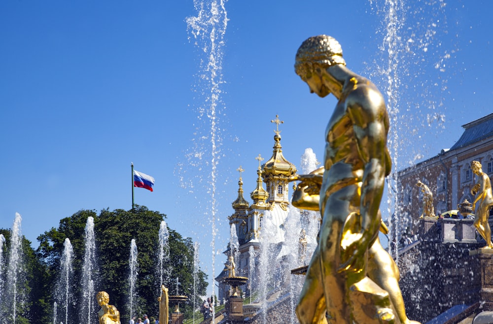 statua d'oro dell'uomo con le bandiere sopra