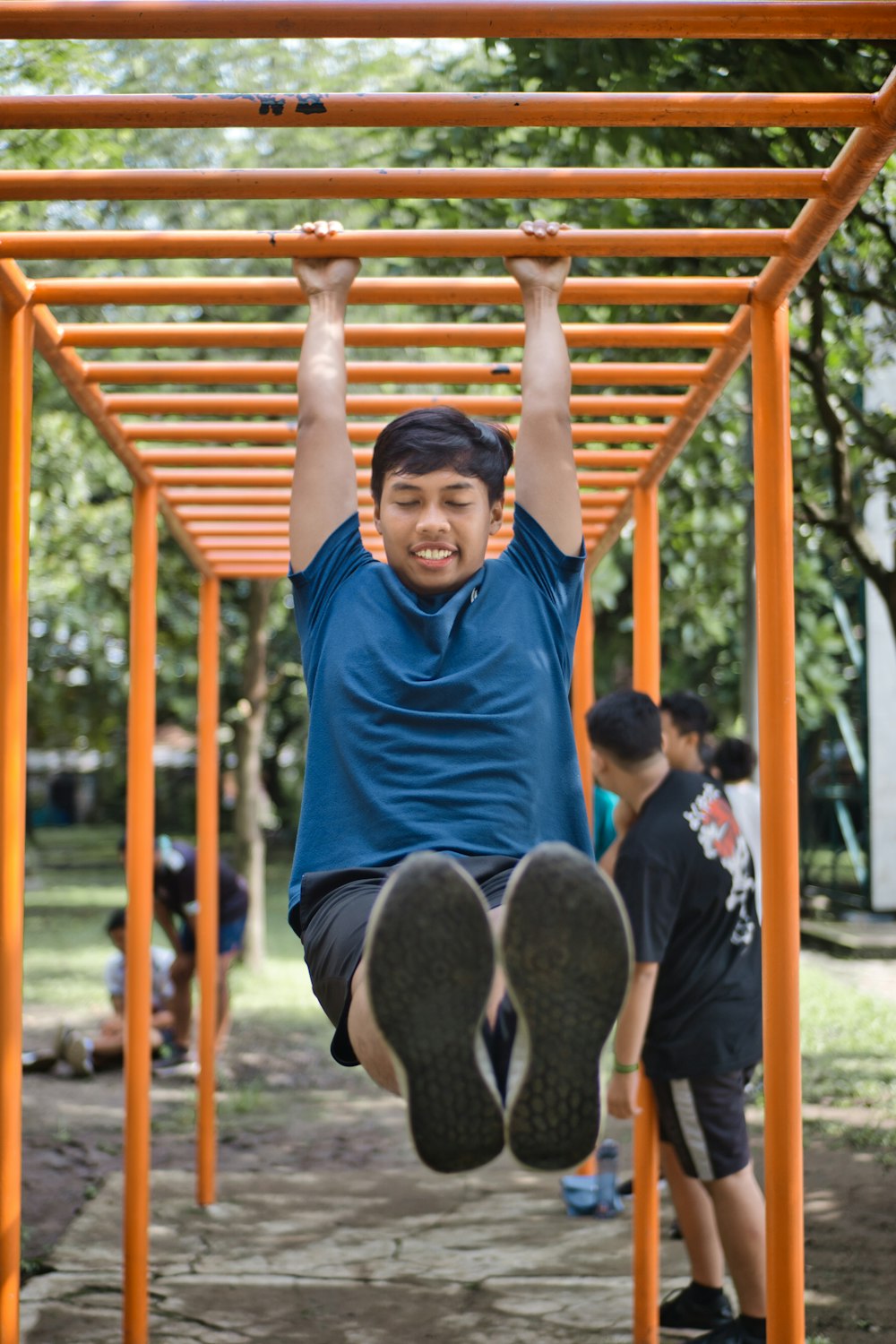 man in blue crew neck t-shirt sitting on brown wooden swing