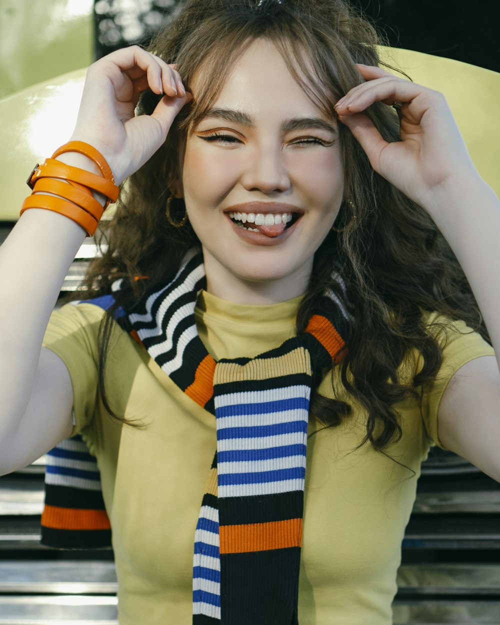 smiling woman in yellow and blue sleeveless dress