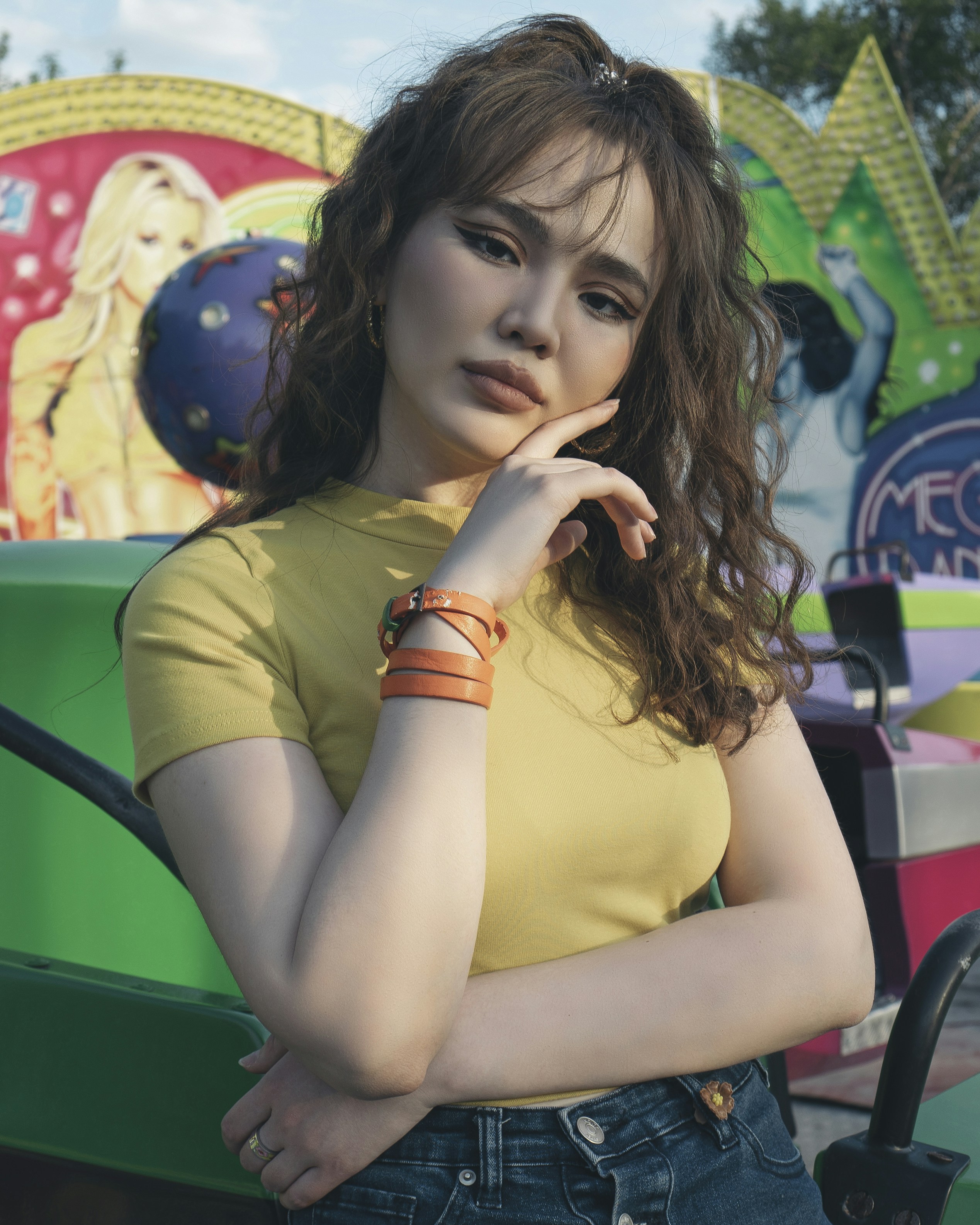 Wanita dengan tank top kuning duduk di kursi hitam