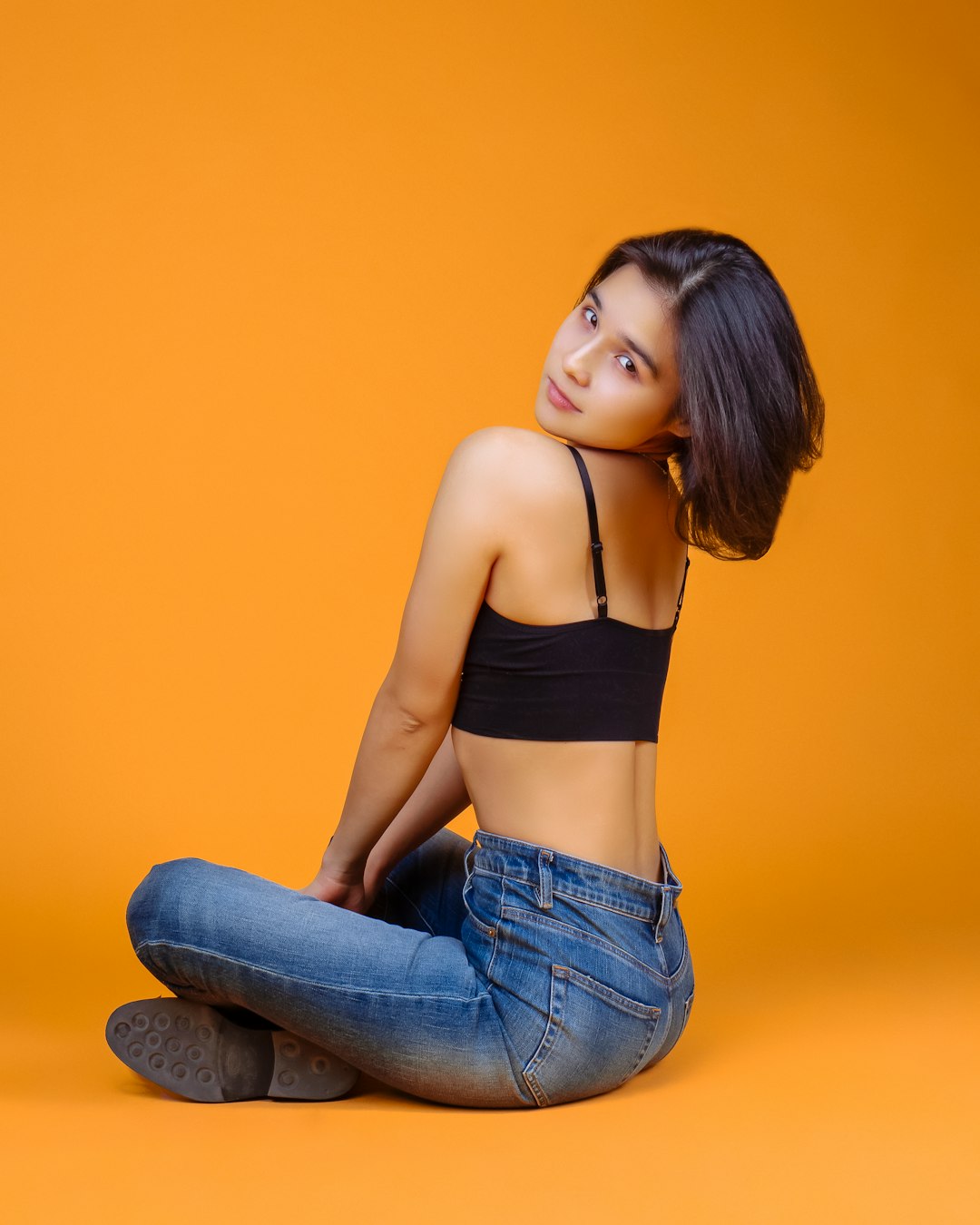 woman in black sports bra and blue denim jeans