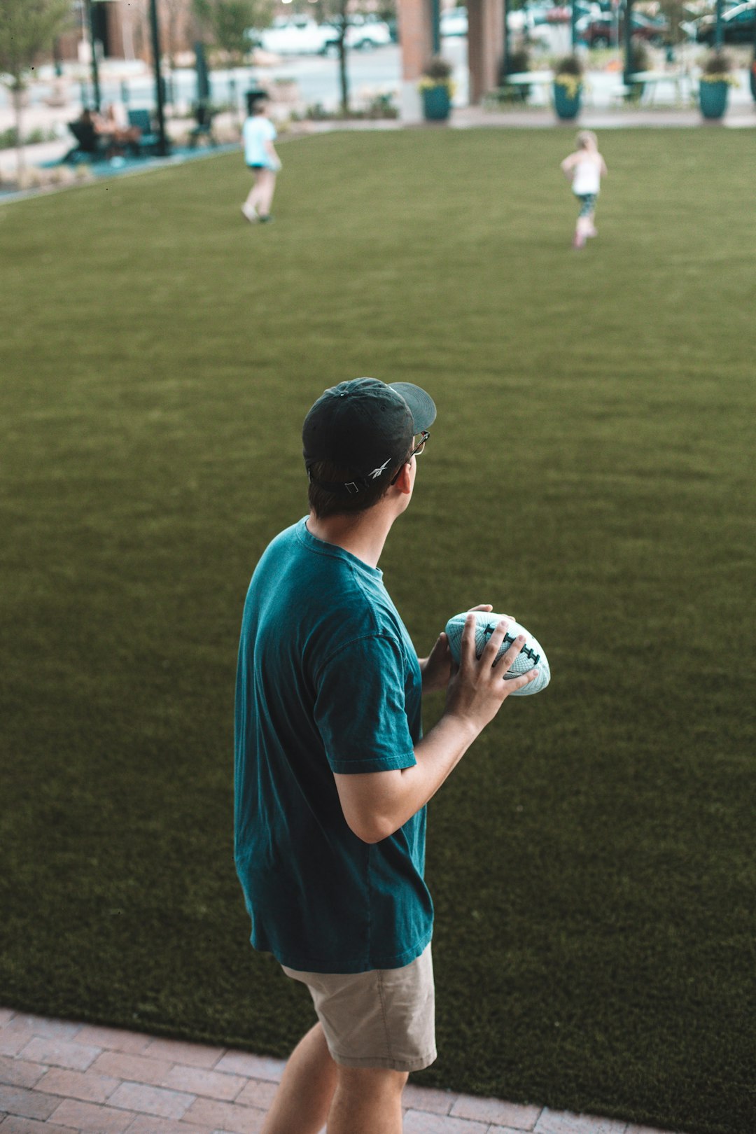 man in blue t-shirt holding white and black soccer ball