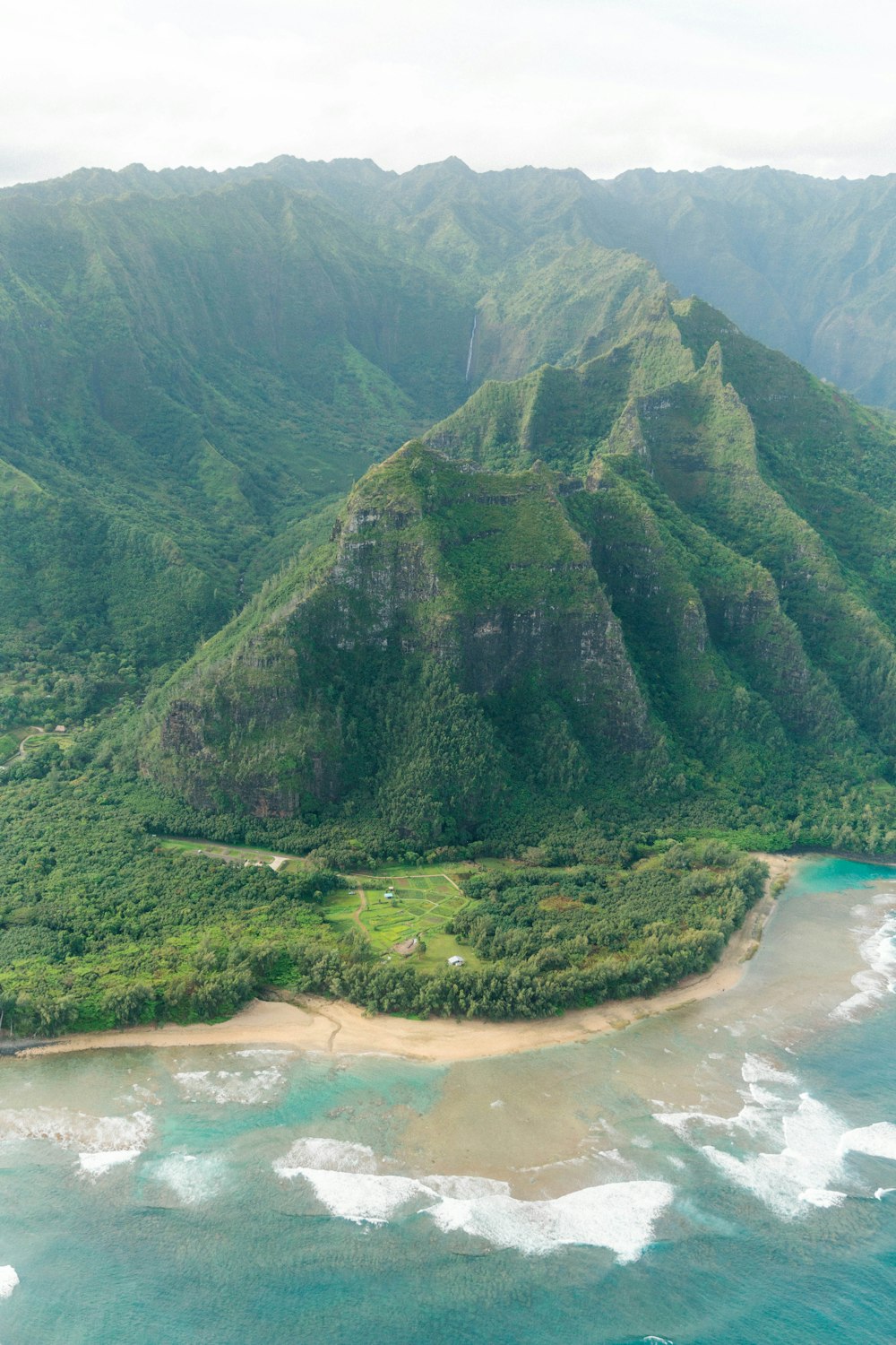 green mountain beside body of water during daytime