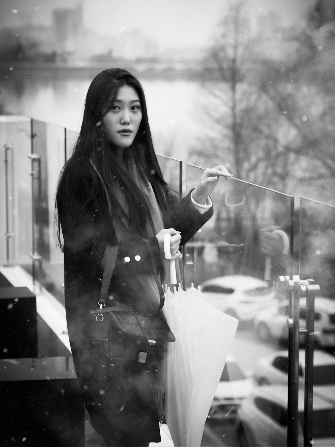 woman in black coat holding clear glass bottle