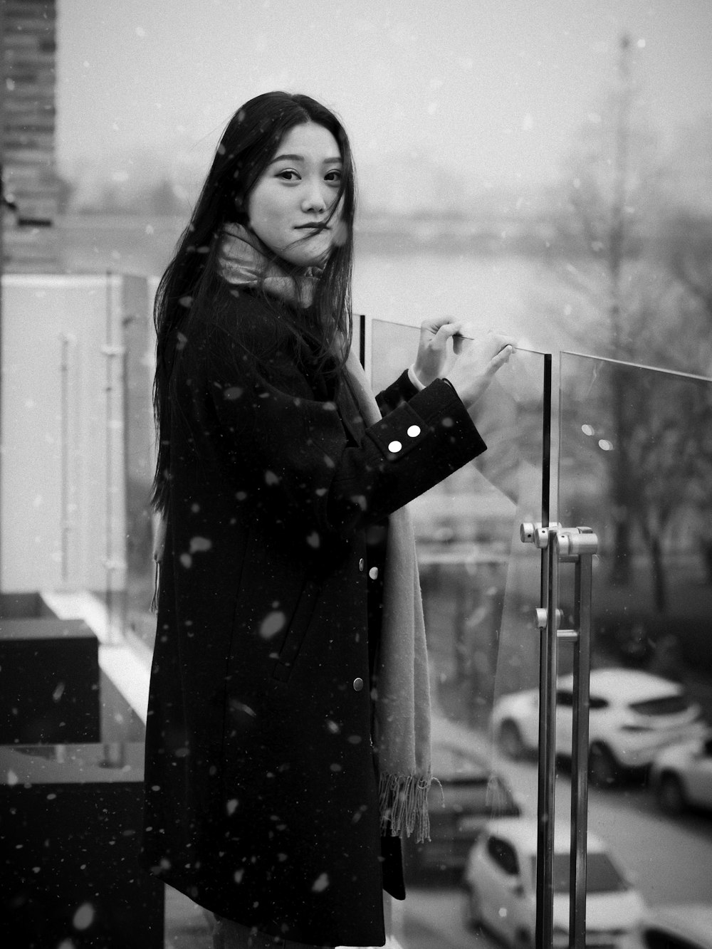 a woman standing on a balcony in the snow