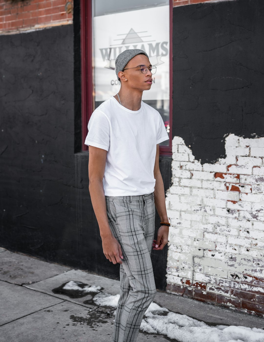 woman in white crew neck t-shirt and gray plaid pants standing beside red and black