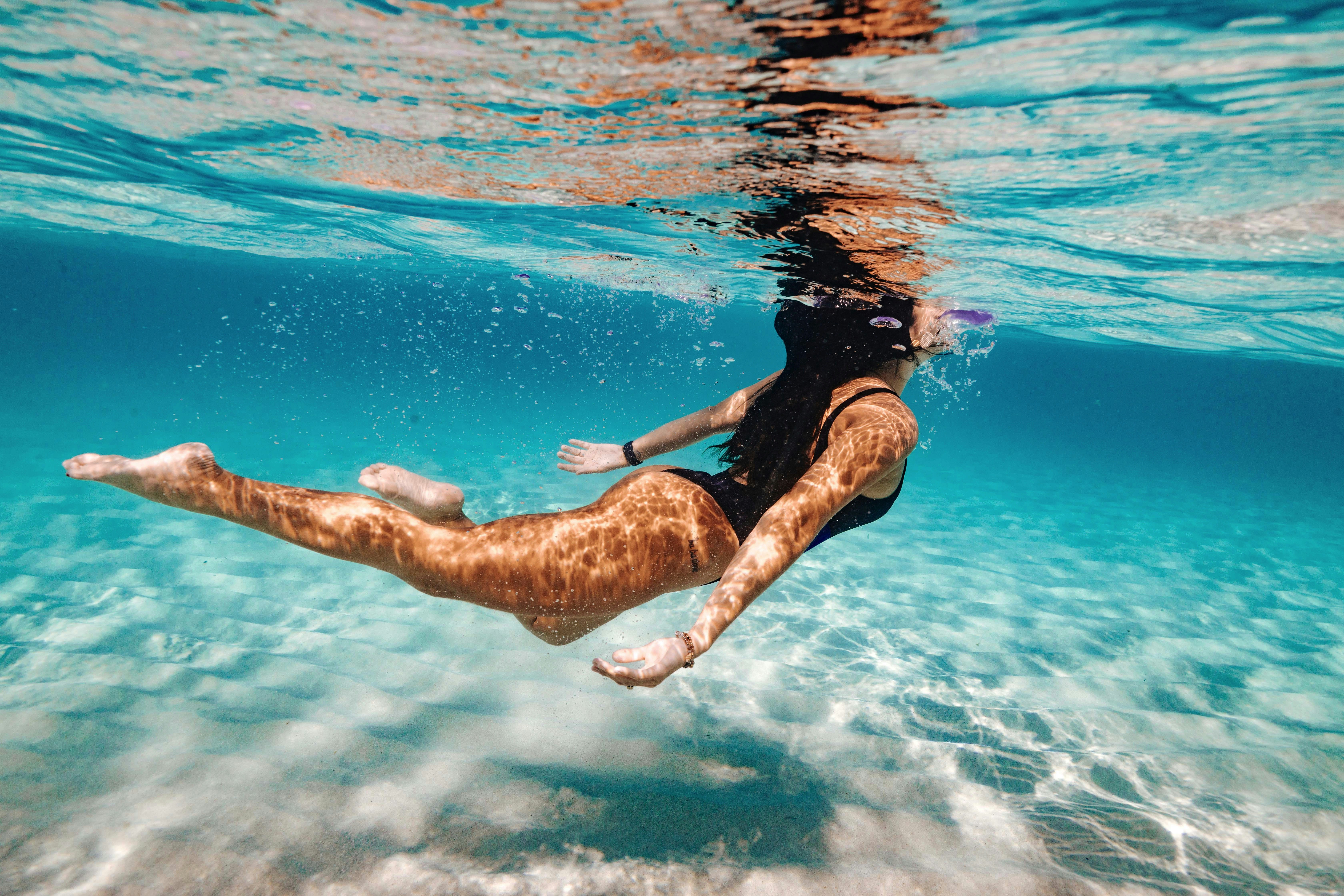 man in black shorts jumping on water