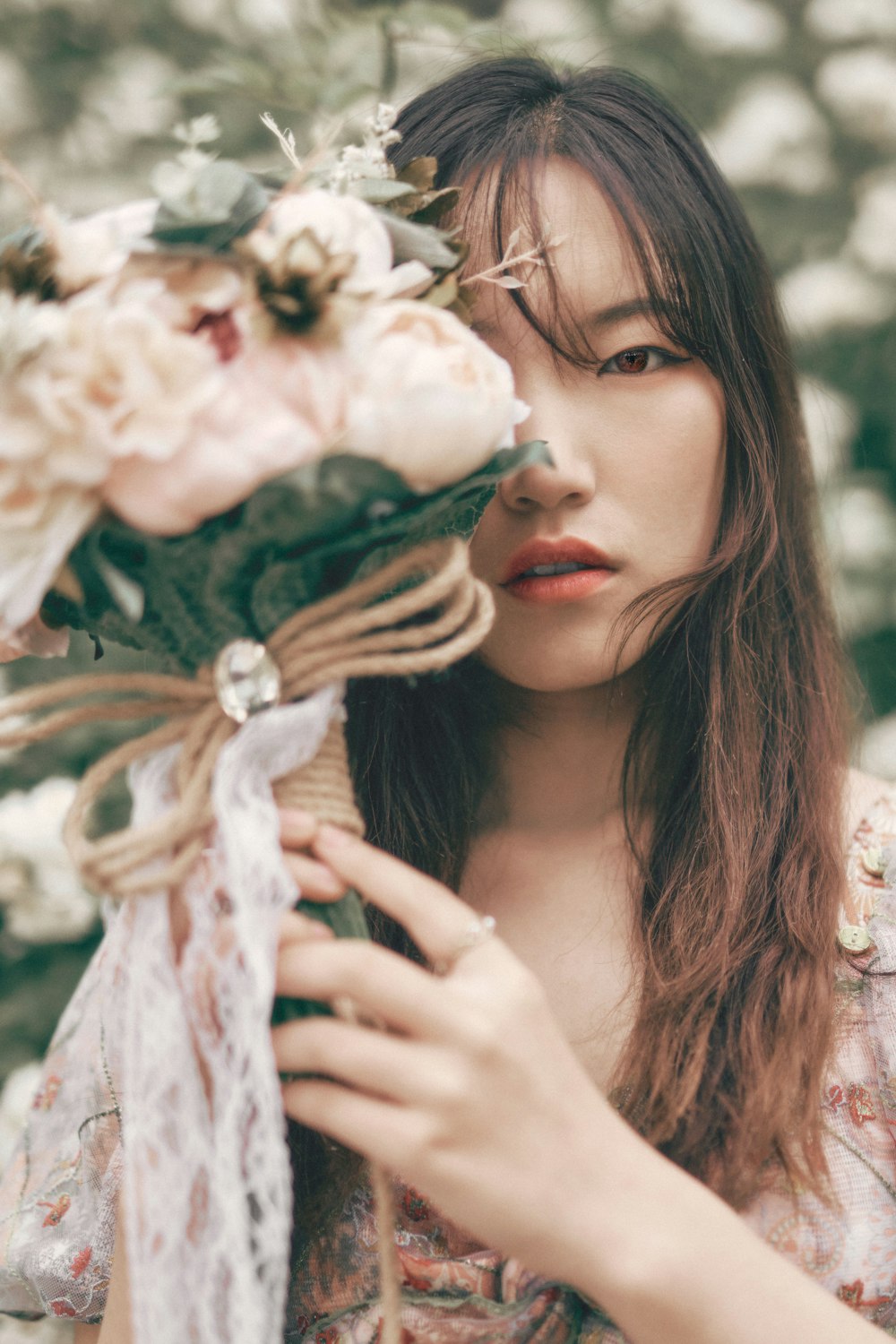 woman in white floral dress holding white flower