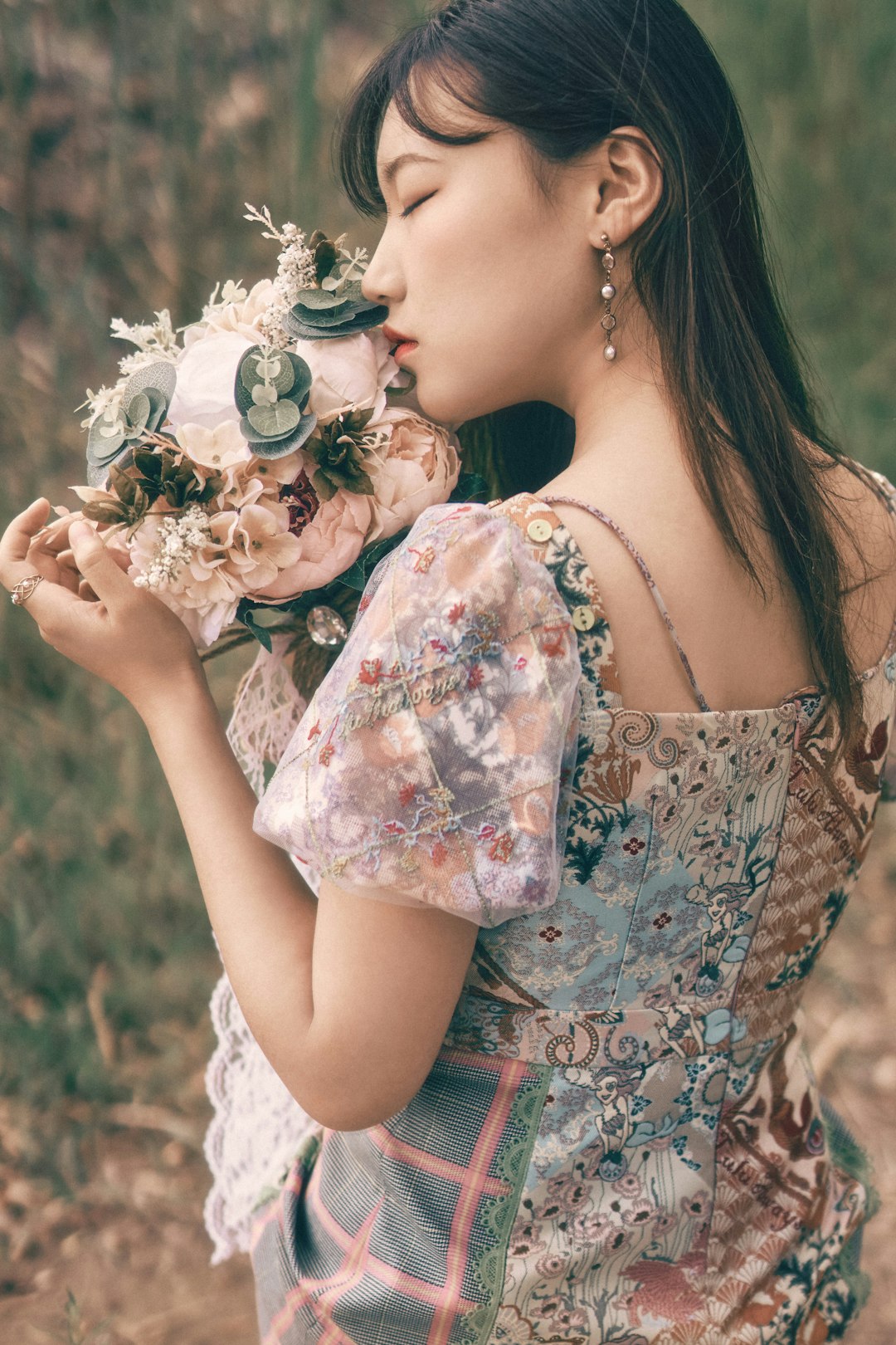 woman in white and red floral dress holding white flower