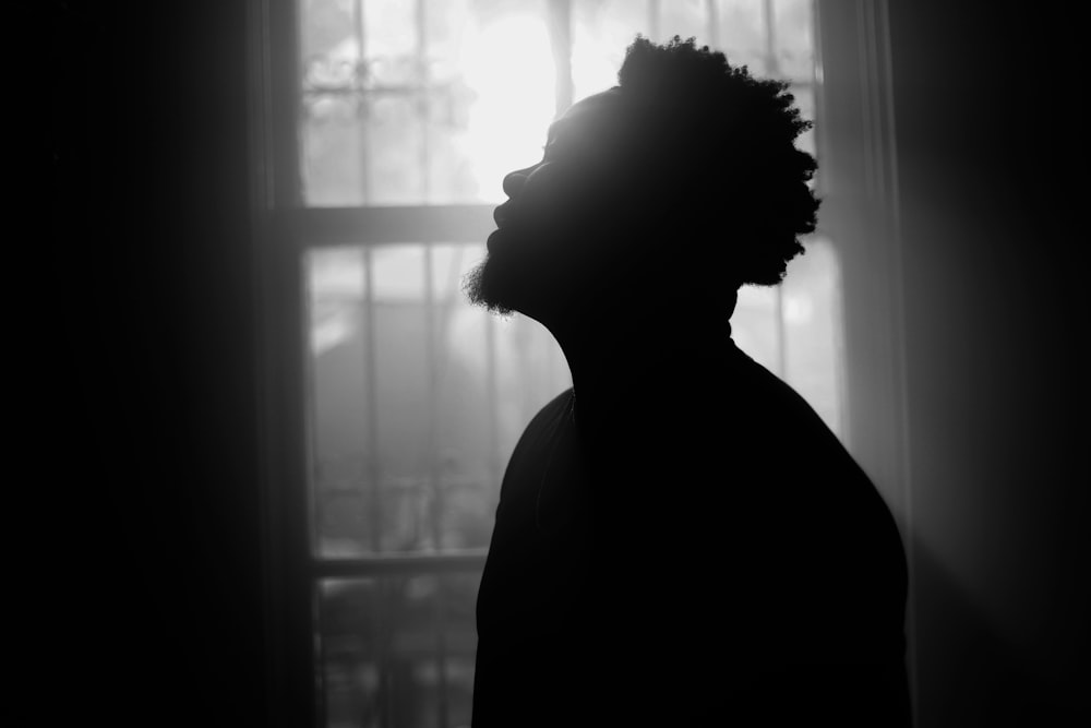 silhouette of person standing near window