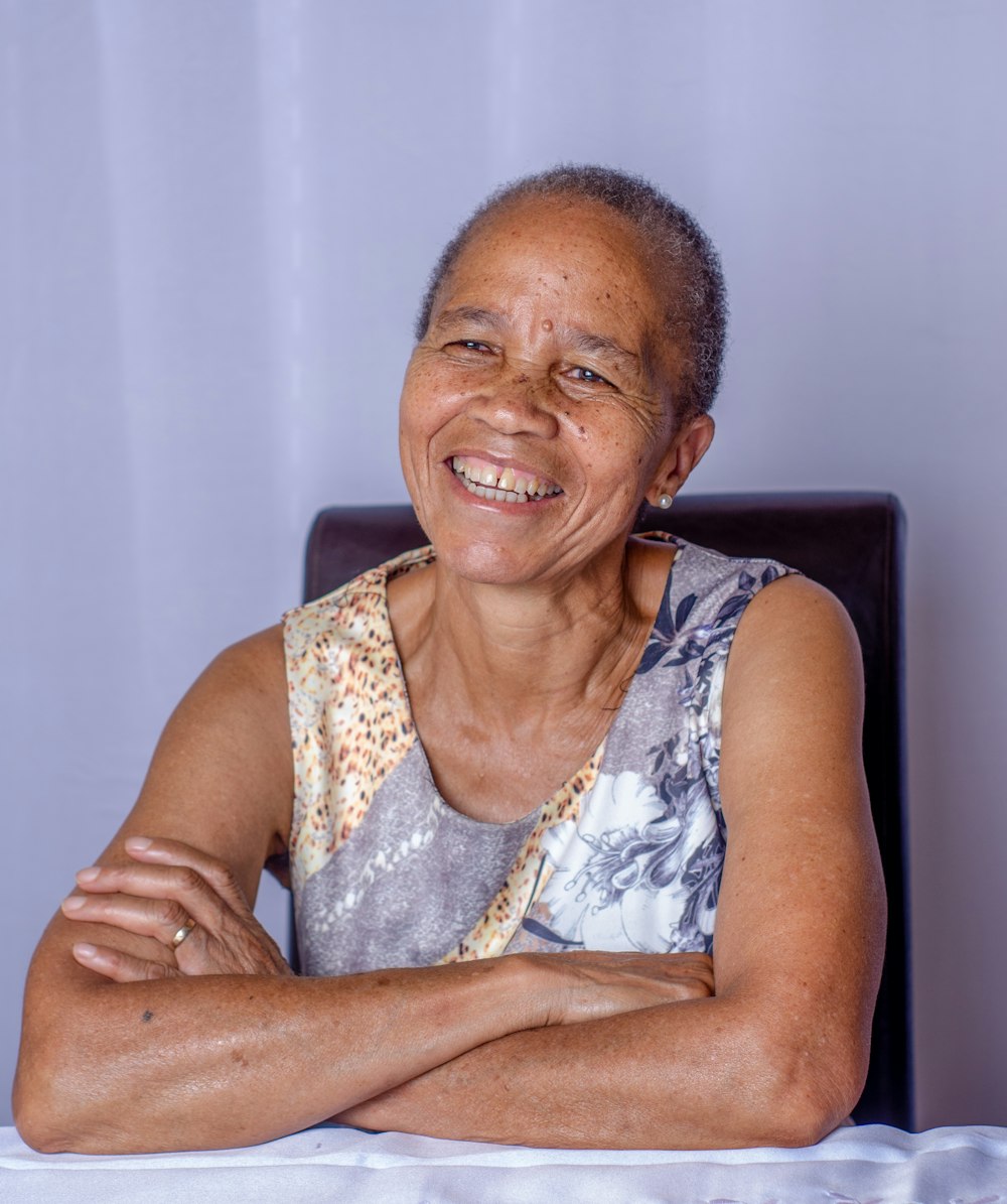 woman in white and gray tank top sitting on black chair