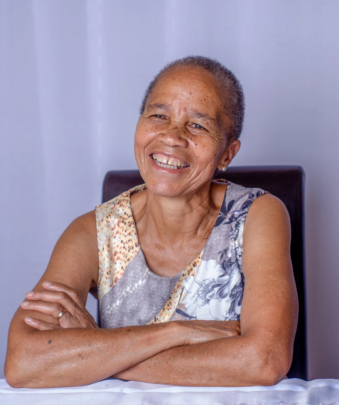 Senhora sorrindo de braços cruzados