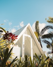 white wooden house with red flowers