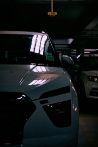 Close-up of a shiny used car being inspected by a professional in a garage.