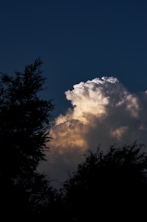 A vivid photo of a mushroom cloud rising over a test site at sunset.