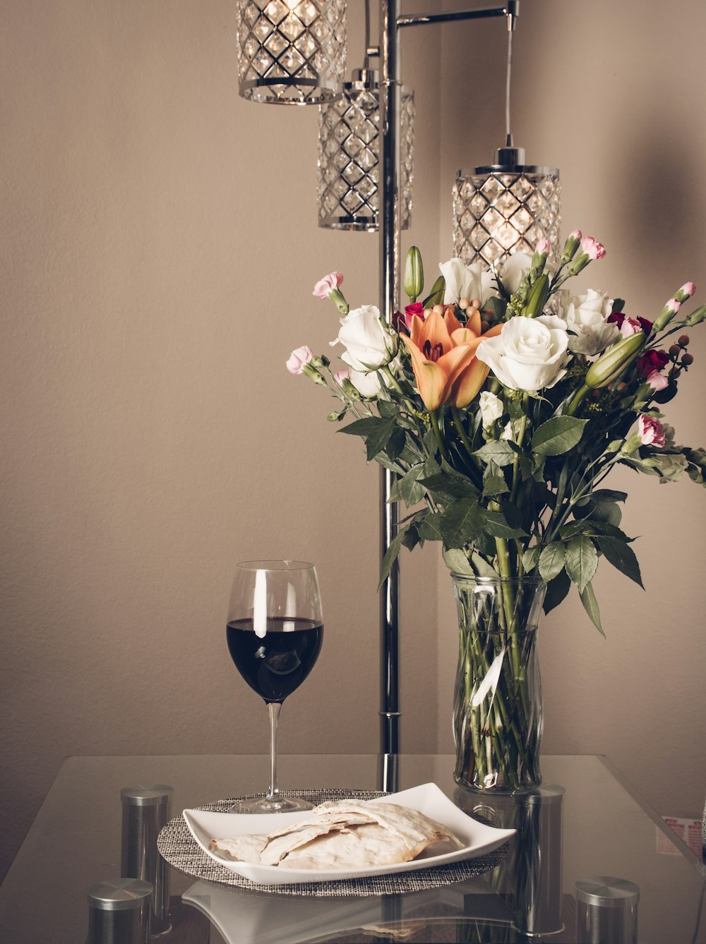 white and yellow flowers in clear glass vase on table