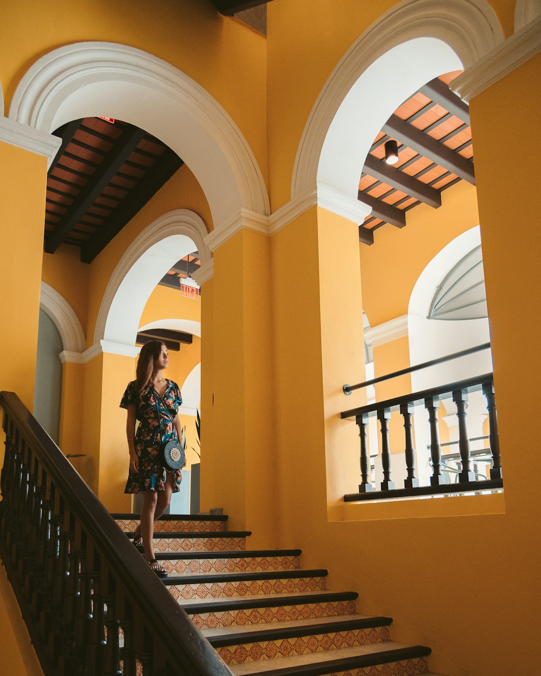 woman in black dress standing on brown wooden staircase