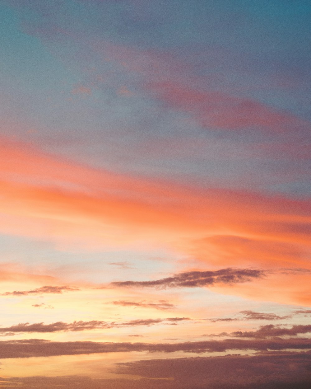 Ciel nuageux orange et bleu au coucher du soleil