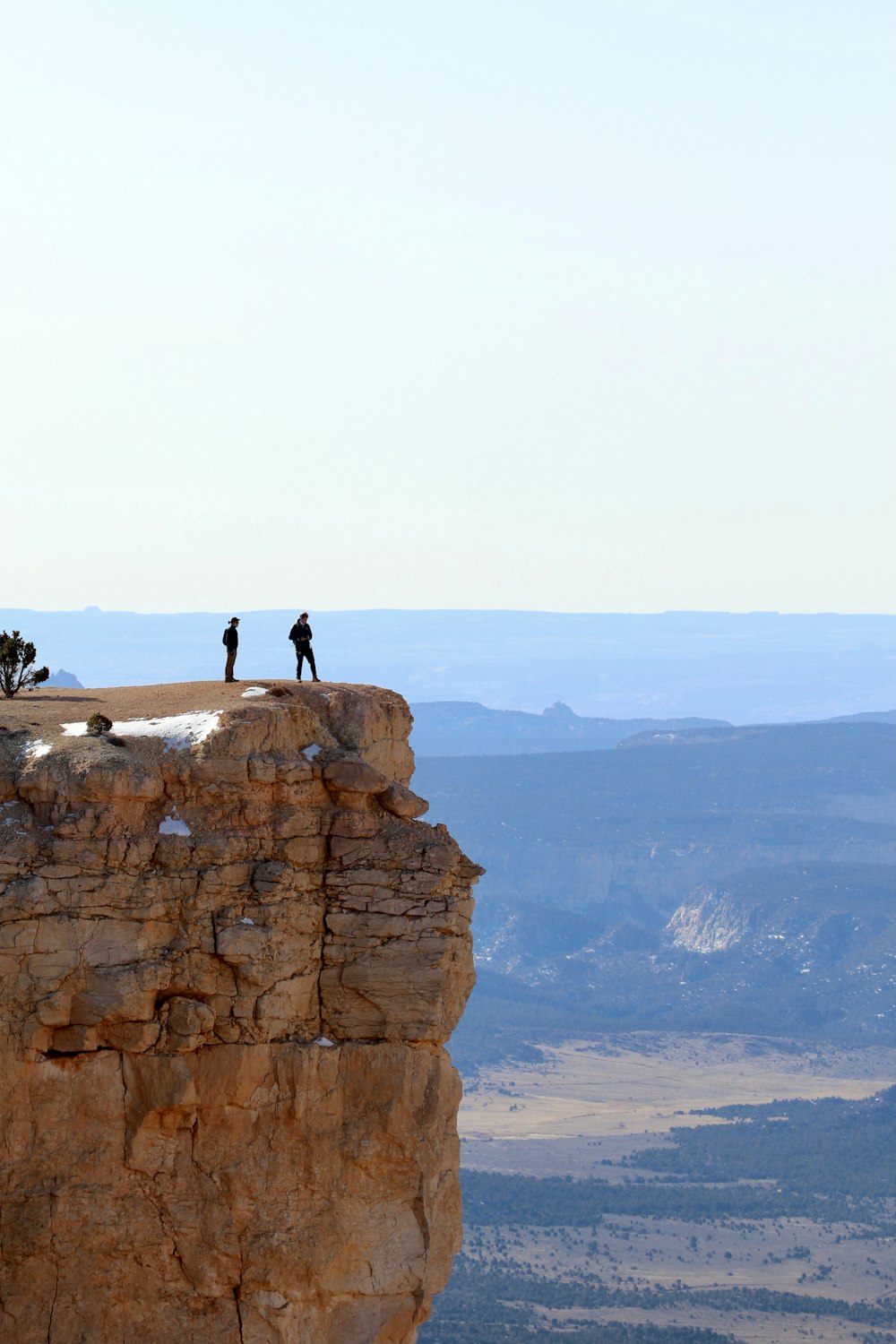 people standing on brown rock formation during daytime