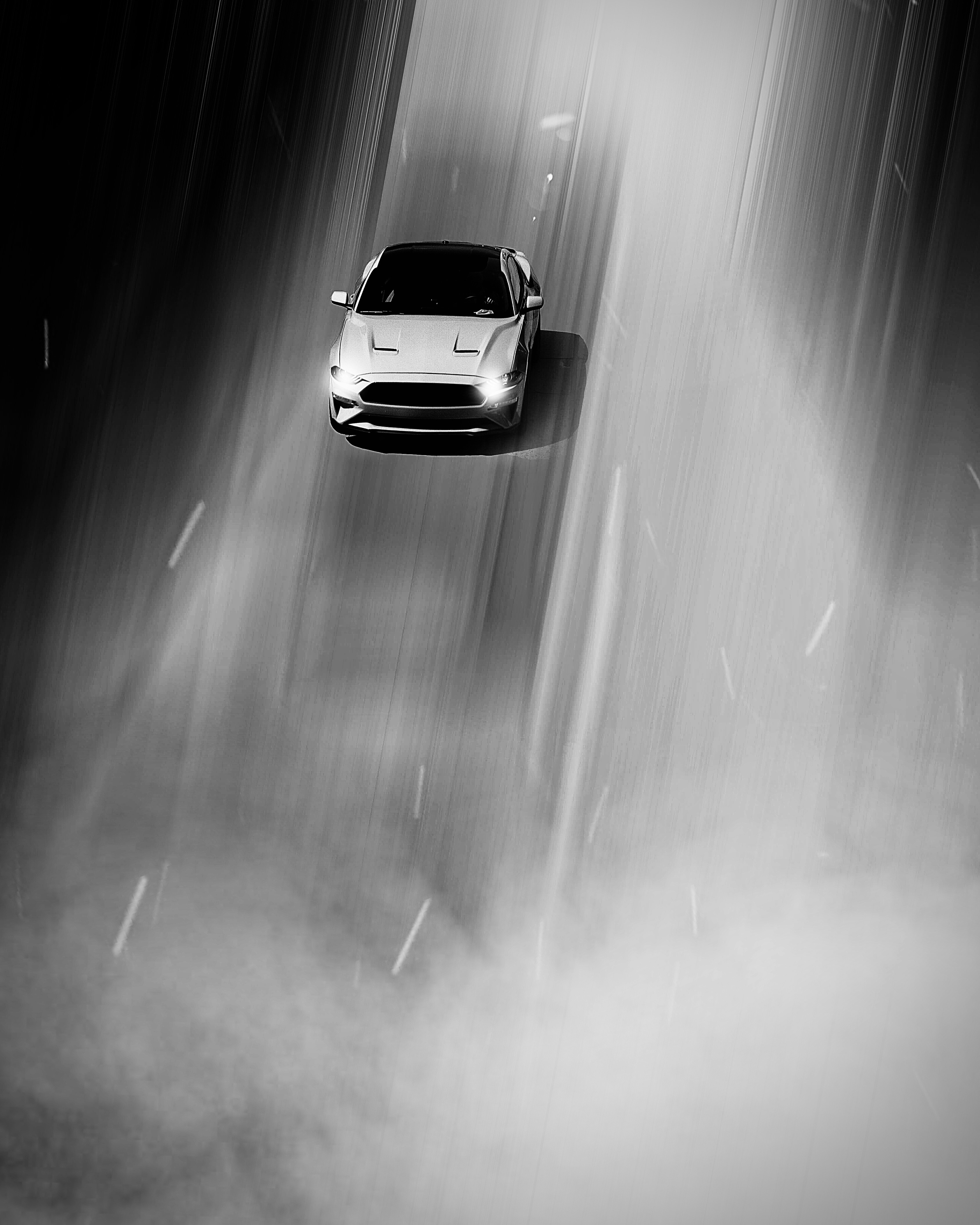 Sleek sports car on dark road at night, dramatic low-key lighting, deep shadows, cinematic atmosphere