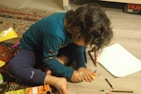 A young person happily coloring with markers at a cozy desk.
